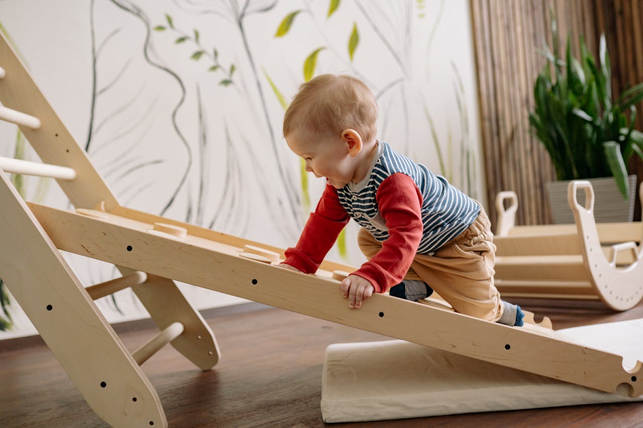 our-story A young child enjoys climbing a wooden toy ladder indoors, promoting playtime and activity.